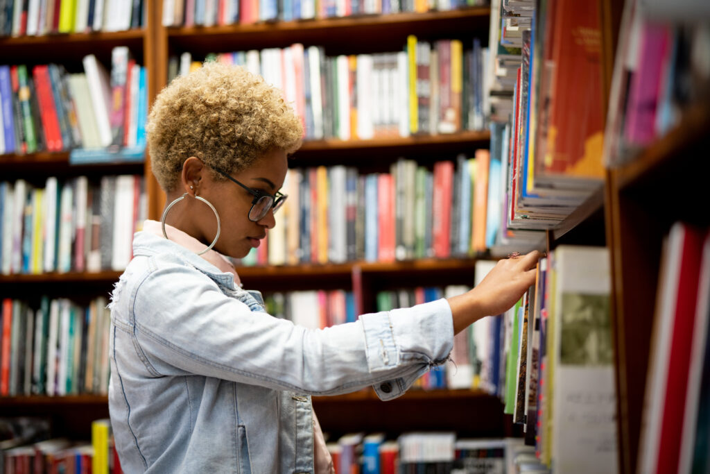 Woman reviewing books on shelves